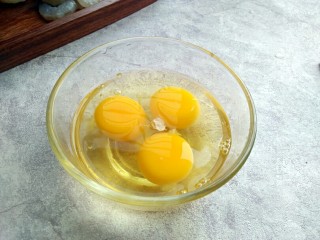 芹菜鸡蛋炒虾仁,鸡蛋打入碗中
