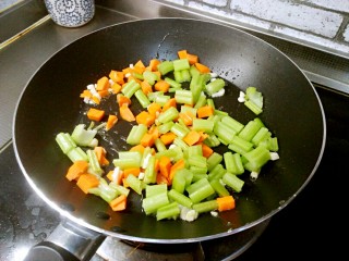 芹菜鸡蛋炒虾仁,将芹菜和胡萝卜加入锅中。