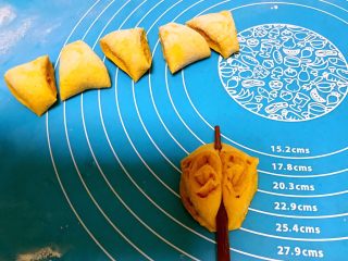南瓜蝴蝶花卷,切成小三角块，把两个面块摞在一起，用筷子轻轻压扁