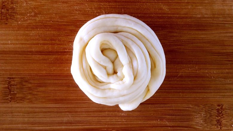 发面盘丝饼,把长条从一头向另一头卷起。，卷成圆形。