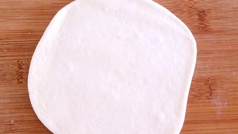 发面盘丝饼,拿出其中一个面团，擀成圆薄片。