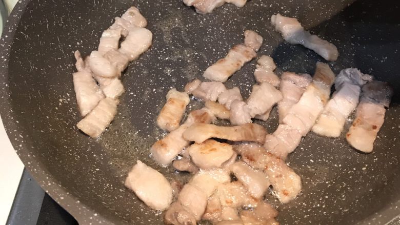 豉香茶树菇炒回锅肉,锅内放少许油，将五花肉炒成至肉片焦黄并微微卷起