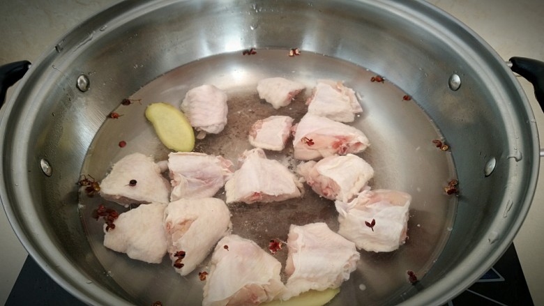 鸡中翅烧土豆,锅中放入凉水，放入花椒粒，姜片，鸡翅，煮开戳水。