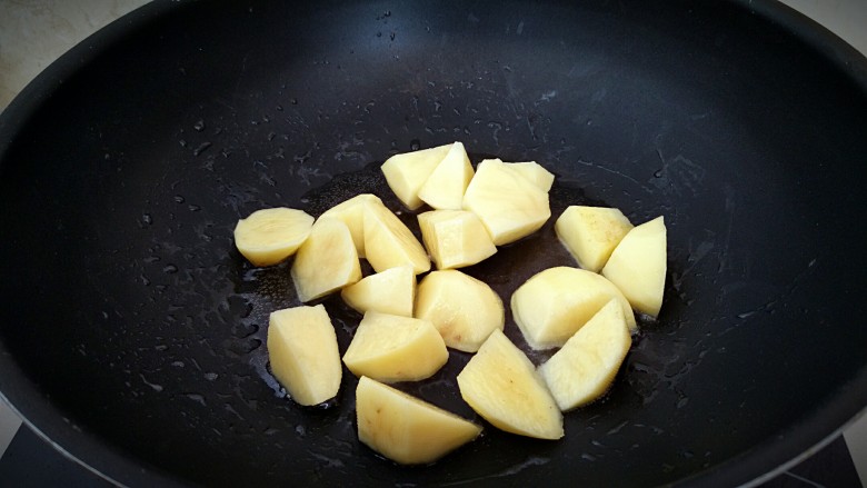 鸡中翅烧土豆,锅中刷一层油，放入土豆块小火煎。