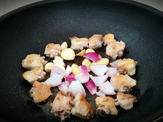 鸡中翅烧土豆,放入洋葱，姜片，大蒜和鸡翅一起煎至出味。