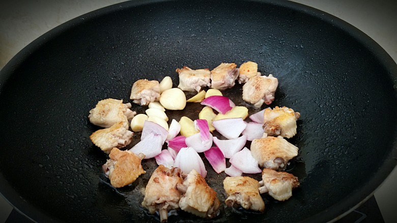 鸡中翅烧土豆,放入洋葱，姜片，大蒜和鸡翅一起煎至出味。