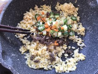 黄金蛋炒饭,用筷子打散米饭，倒入焯熟的蔬菜。