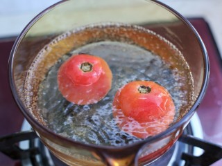 番茄肉酱意面,锅中烧开水，将番茄划十字的部位朝下放入水中烫煮约三十秒