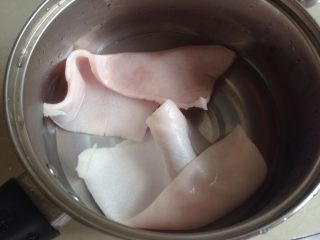 青红椒炒猪皮,猪皮去干净毛，待锅里的水烧开后放入猪皮煮2分钟，切成小块