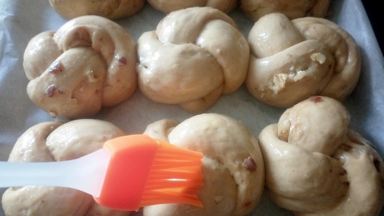 #甜味#红糖红枣核桃面包,二次发酵好取出刷蛋液，取出的时候就可以预热烤箱180度10分钟