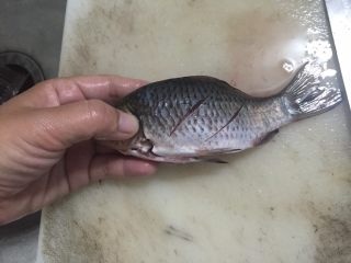 椒盐鲫鱼,然后把鱼的身体用刀子划两个口，这样更容易熟，腌制时更容易入味。