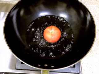 番茄酱培根意面,锅内放适量的水烧开，将番茄放入锅中，中途要翻面，使番茄的皮脱离
