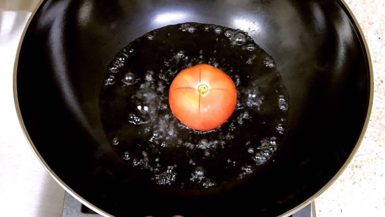 番茄酱培根意面,锅内放适量的水烧开，将番茄放入锅中，中途要翻面，使番茄的皮脱离