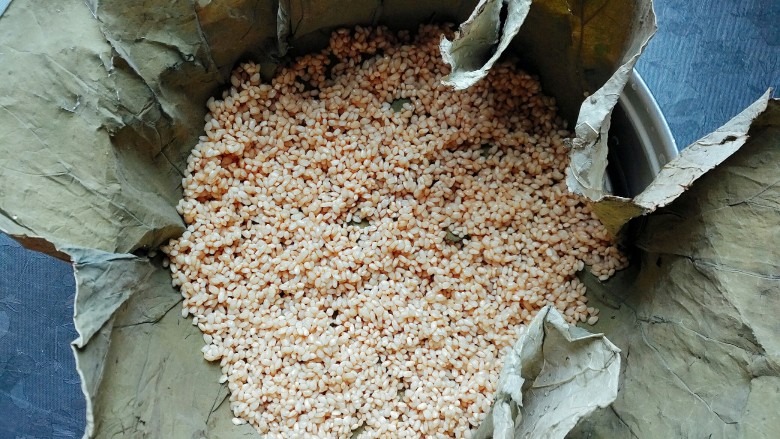 荷叶糯米蒸排骨,把荷叶铺平，铺一层糯米，注意要铺均匀