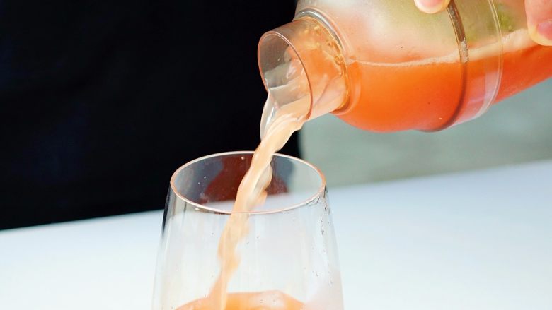 夏日红柚季！比基尼少女的鸡尾酒,在玻璃杯中加适量的冰块，将鸡尾酒倒入杯中