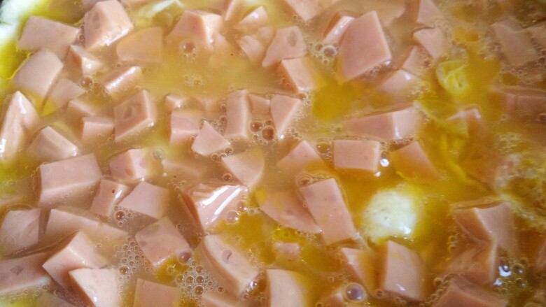 快手早餐——肉松火腿芝士三明治,小煎锅中放油，油热倒入鸡蛋液。