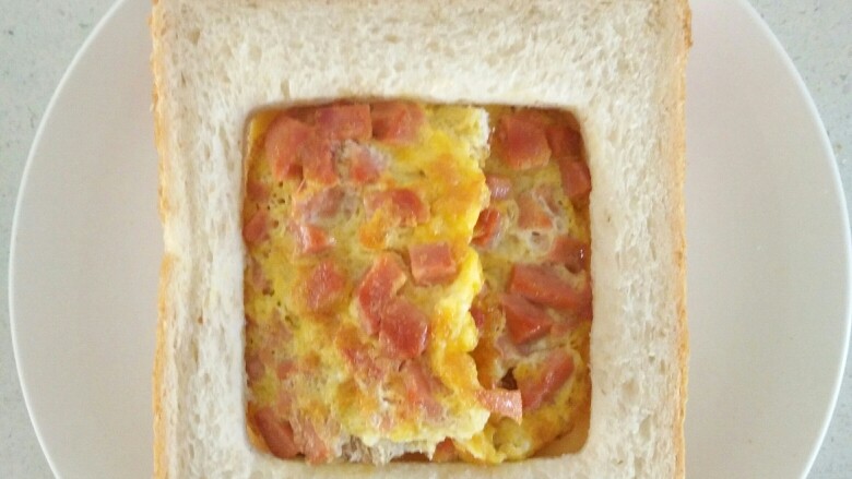 快手早餐——肉松火腿芝士三明治,加入摊好的鸡蛋火腿丁饼。