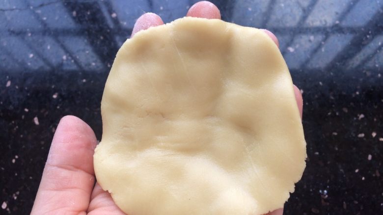 广式冰皮蛋黄月饼,松弛好的广式饼皮同样分成6等份，每份30克，把饼皮搓圆放手心中轻轻压成薄饼状。