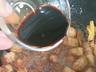 红烧樱桃肉,炒至糖溶后加入酱油，继续翻炒至肉上色。