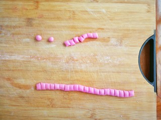 美少女粉红圆子燕麦酒酿,每个小方块都搓成圆球形状，重复上一步骤依次做完所有的面团，