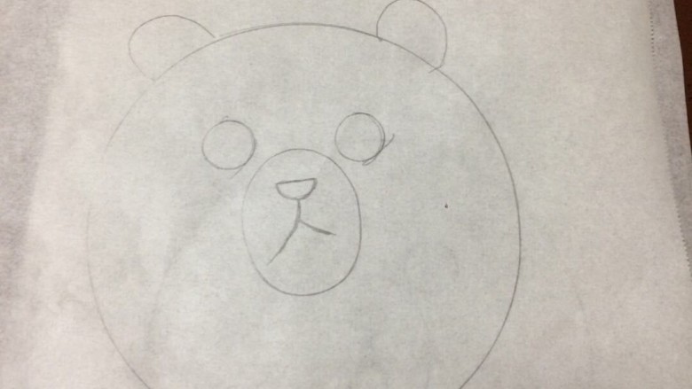 #甜味#布朗胖熊焦糖布丁,首先我们来做装饰部分，取一张烘培油纸，画一个熊头，我画的不好，请不要笑我木有艺术细胞哈哈...
