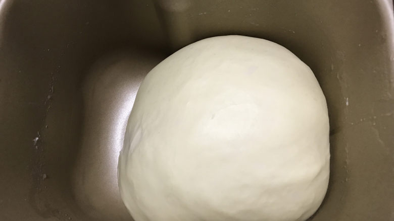 12连汉堡小面包,面团盖上保鲜膜，发酵至两倍大。大约1小时。温度控制在28度左右。室温比较高可以放入冰箱冷藏发酵。室温较低可以放入烤箱开30度，放一碗温水发酵。