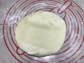 12连汉堡小面包,揉面垫上撒手粉（高筋粉），取出发酵好的面团，轻压排气。