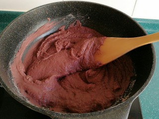 自制红豆沙馅,将过筛后的红豆泥放入不粘锅里，开到中火。最好要用不粘锅哦。