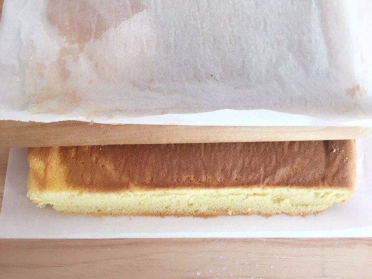 原味蛋糕卷,左右两边直切掉不规则的部分，前后两边斜切，借助擀面棍
上面再铺一张油纸，连同油纸一起卷进去；
