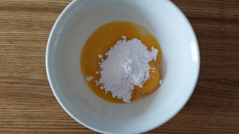 蛋香葡萄干咖啡吐司（面包机一键）,准备蛋黄皮，蛋黄打入碗内，加入糖粉，用手抽打撒