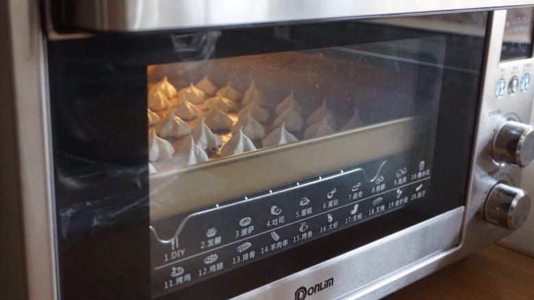 柠檬蛋白糖,放入已经预热到100度的烤箱中下层（各家烤箱脾气不同，温度仅供参考，我家烤箱温度挺准的，用烤箱温度计测量过），烘烤50分钟左右