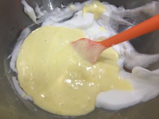 多彩云朵：中空戚风蛋糕,将蛋黄糊倒入剩余的蛋白霜里，翻拌均匀；