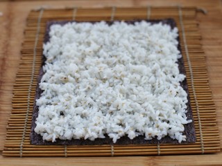 金枪鱼寿司,取适量米饭均匀的铺到紫菜上，最上边留一条不放米饭