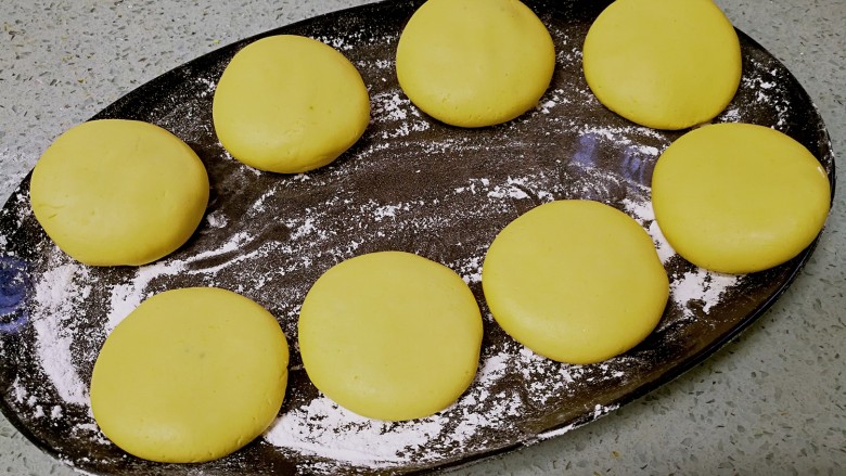红糖南瓜饼,做好的饼胚铺放在撒了糯米粉的盘子或案板上备用。