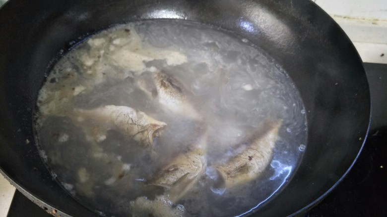 鲜美鲫鱼汤,两面都煎好后，锅中加一大碗水，大火烧开。