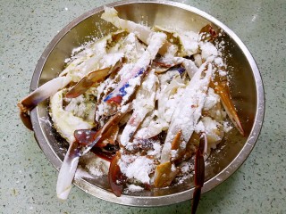 姜葱炒花蟹,花蟹控干表面水分，下锅前撒入生粉，捞匀，让每块花蟹都沾上生粉。