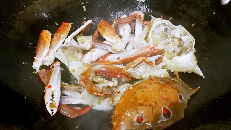 姜葱炒花蟹,约30秒后翻动花蟹，每翻动一次就静置一会儿，让花蟹处于半炸半煎半炒的状态。