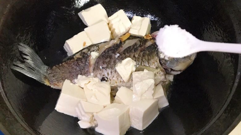 浓汤鲫鱼炖豆腐,倒进豆腐，撒适量盐
