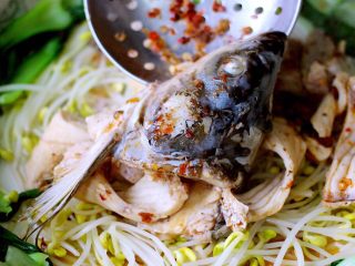 #辣味#麻辣水煮鱼,把煮熟的鱼头和鱼排捞出沥干放入码菜的盆里