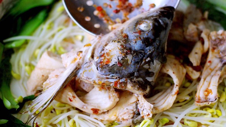 #辣味#麻辣水煮鱼,把煮熟的鱼头和鱼排捞出沥干放入码菜的盆里