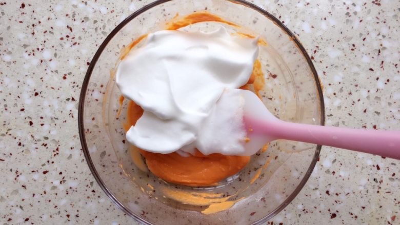 胡萝卜溶豆,分3/1蛋白霜到胡萝卜泥碗里，翻拌均匀；