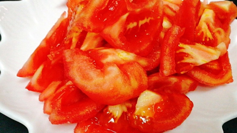 西红柿炒鸡蛋,番茄去蒂，用沸水烫一下去皮，也可以削皮可以卷花当摆盘，去皮后切成小块备用。