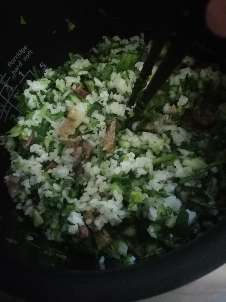 猪油咸肉香肠菜饭,加入青菜用筷子拌匀后继续焖煮。（可酌情加入盐调味）