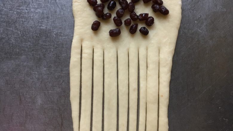 蜜豆酸奶手撕小面包,上面1/3处撒上些许蜜豆，下面用切板或刀切分成一条条的。