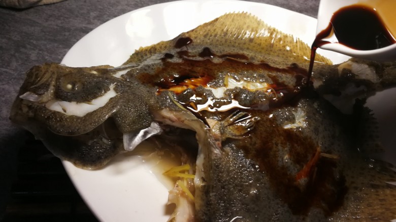清蒸多宝鱼,淋上蒸鱼豉油，将枸杞子放在鱼身上。