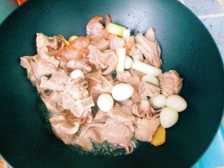 家庭版麻辣香锅,倒入葱姜蒜爆炒，倒入肉类海鲜和鹌鹑蛋翻炒至变色