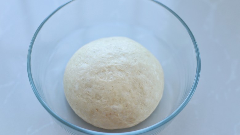 全麦辫子面包,将面团放入容器中，覆盖保鲜膜放到温暖处进行发酵