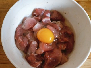 菠萝咕噜肉,腌渍好的肉中放入一个鸡蛋，搅拌均匀备用。