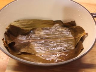 香鱼甘露煮,炖锅摆上几片竹叶铺底，这样可以避免鱼体沾黏锅底。也可以在竹叶上再铺上几片昆布增加风味。