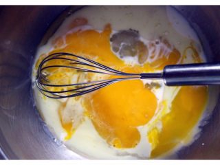 #甜味#杏仁纸杯蛋糕,把蛋白和蛋黄分离、我把分离的蛋白放入冰箱冷藏、这样一会打发的时候、比较好打发、蛋黄加5克白糖、20克花生油和牛奶搅拌均匀乳化